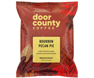 A red bag of Door County Coffee Bourbon Pecan Pie medium roast coffee, featuring a yellow label and decorative autumn leaves, with promotional text above and below on a white background.