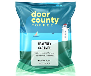 A bag of Door County Coffee Heavenly Caramel medium roast coffee, featuring a blue and green package design with a lighthouse illustration. Text above and below the bag reads 'MAKE THE PERFECT POT' and 'Each 1.